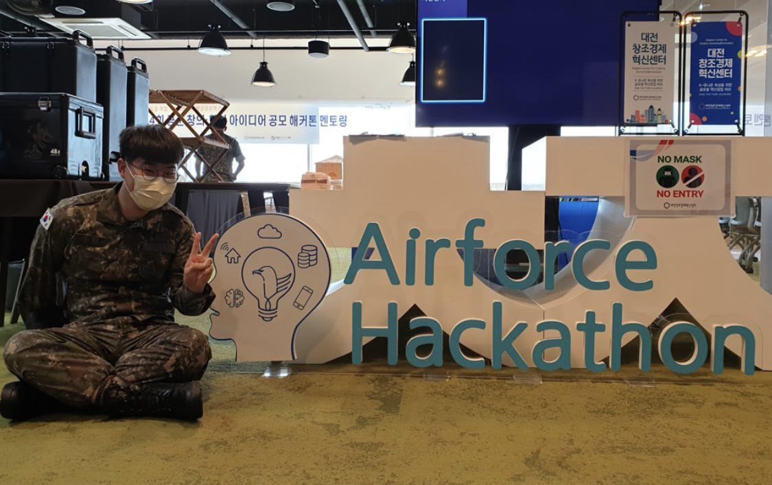 At the hackathon venue in uniform, beside the Airforce Hackathon sign